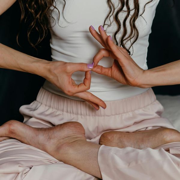 Close-up of hands in a mudra gesture, symbolizing mindfulness and focus.